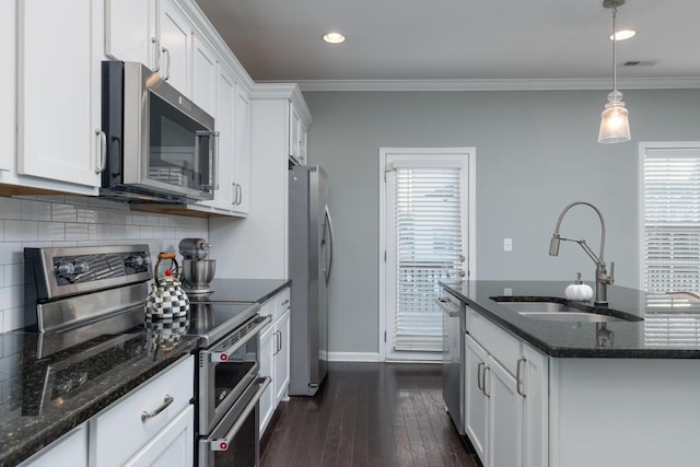 kitchen featuring white cabinets, sink, stainless steel appliances, and hanging light fixtures