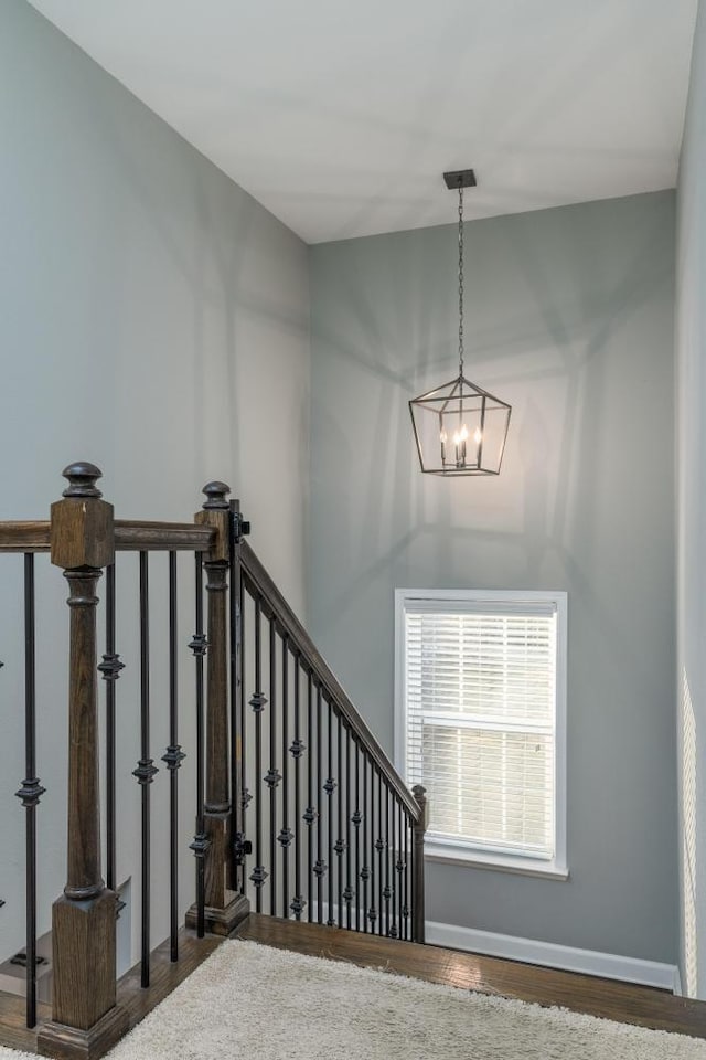 stairway featuring wood-type flooring and a chandelier