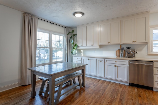 kitchen with stainless steel dishwasher, dark hardwood / wood-style flooring, white cabinets, and a textured ceiling