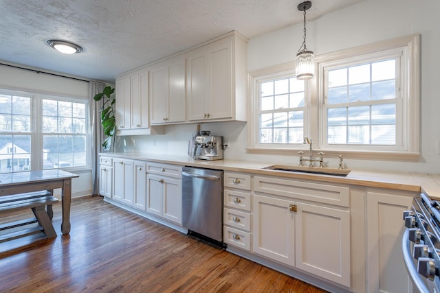 kitchen featuring a textured ceiling, stainless steel appliances, sink, pendant lighting, and white cabinets