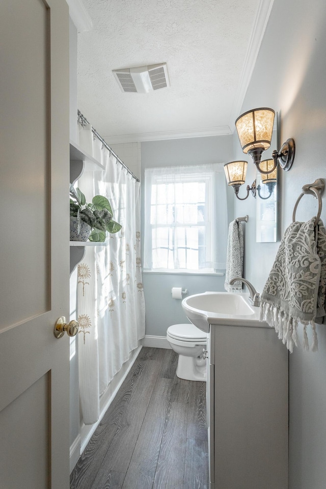 full bathroom featuring vanity, crown molding, hardwood / wood-style flooring, a notable chandelier, and toilet