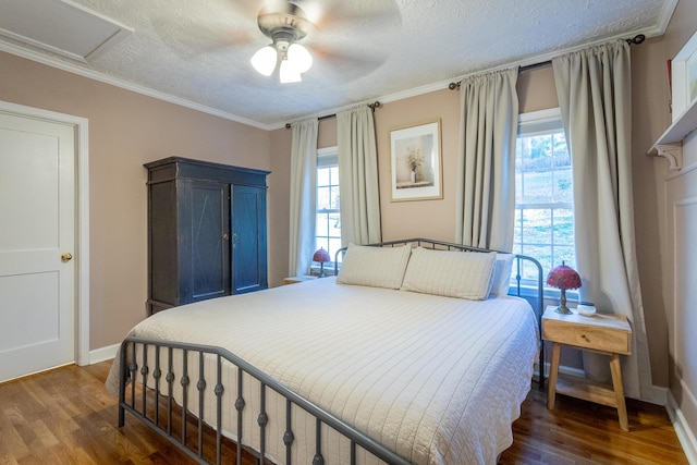 bedroom featuring a textured ceiling, dark hardwood / wood-style flooring, ceiling fan, and crown molding