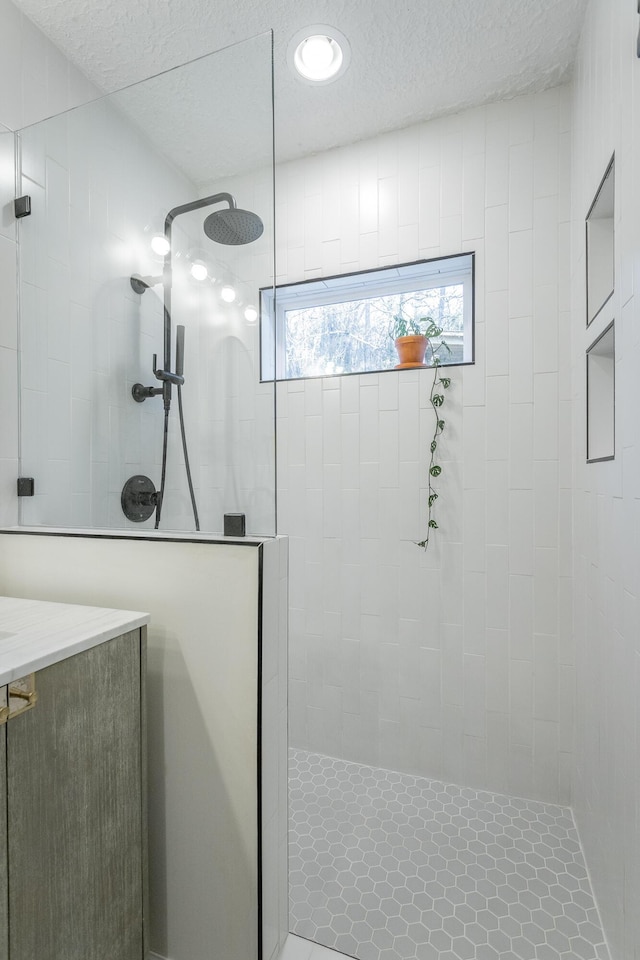 bathroom featuring vanity and tiled shower