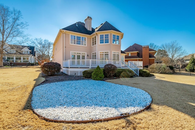 rear view of house with a yard and a wooden deck