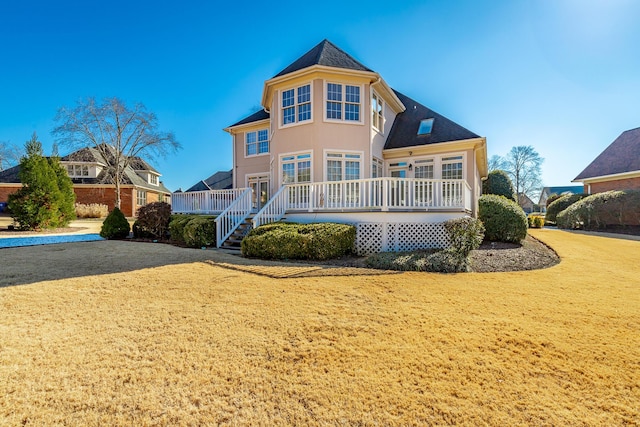 back of property with a lawn and a wooden deck