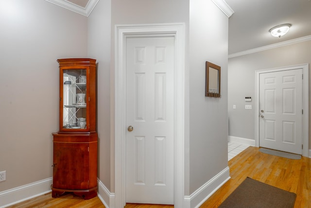 hallway with crown molding and light hardwood / wood-style floors