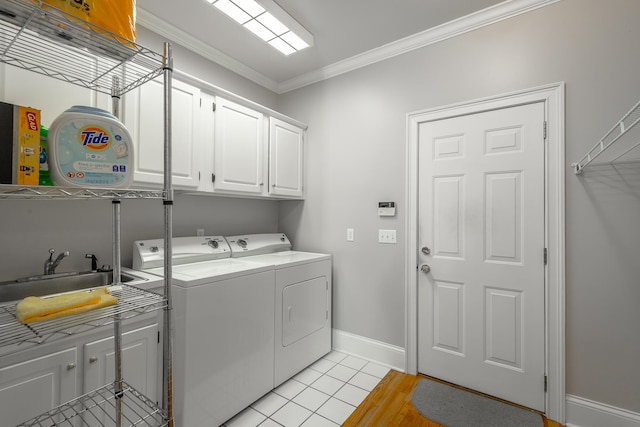 washroom with cabinets, ornamental molding, sink, light tile patterned floors, and independent washer and dryer