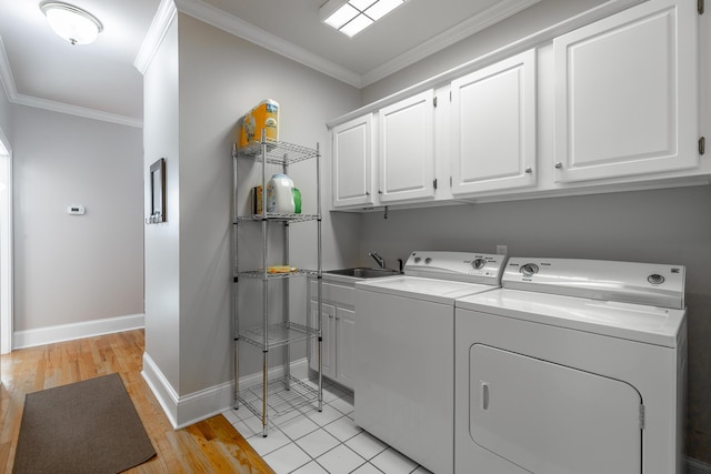 washroom featuring sink, cabinets, independent washer and dryer, light tile patterned flooring, and ornamental molding