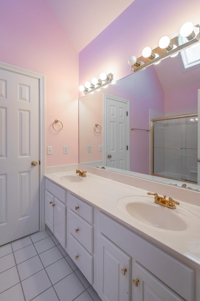 bathroom featuring tile patterned floors, lofted ceiling with skylight, vanity, and a shower with shower door