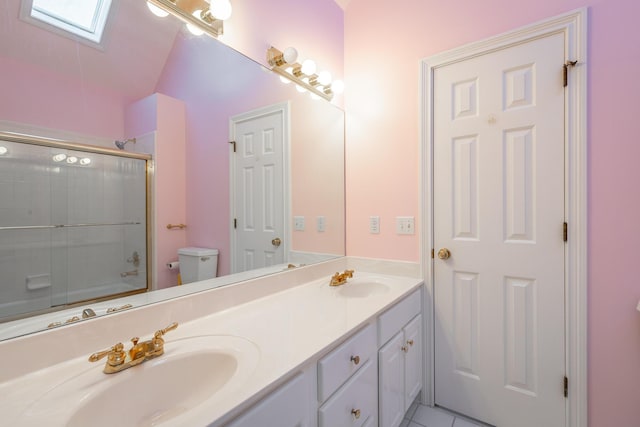 full bathroom with tile patterned floors, vaulted ceiling with skylight, bath / shower combo with glass door, vanity, and toilet