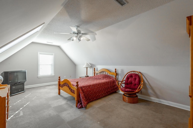 carpeted bedroom with a textured ceiling, vaulted ceiling, and ceiling fan