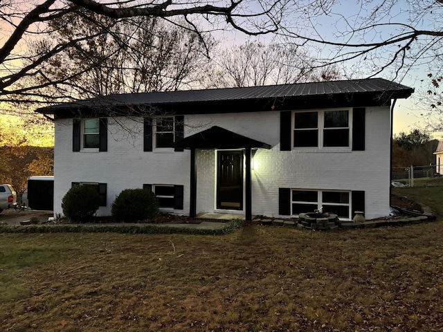 split foyer home featuring a yard