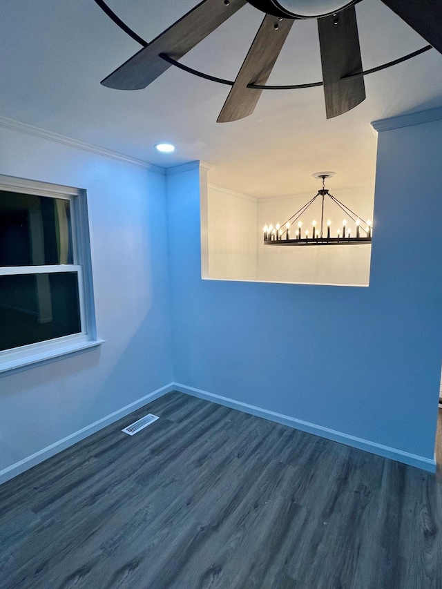 unfurnished room featuring dark wood-type flooring, ornamental molding, and a notable chandelier