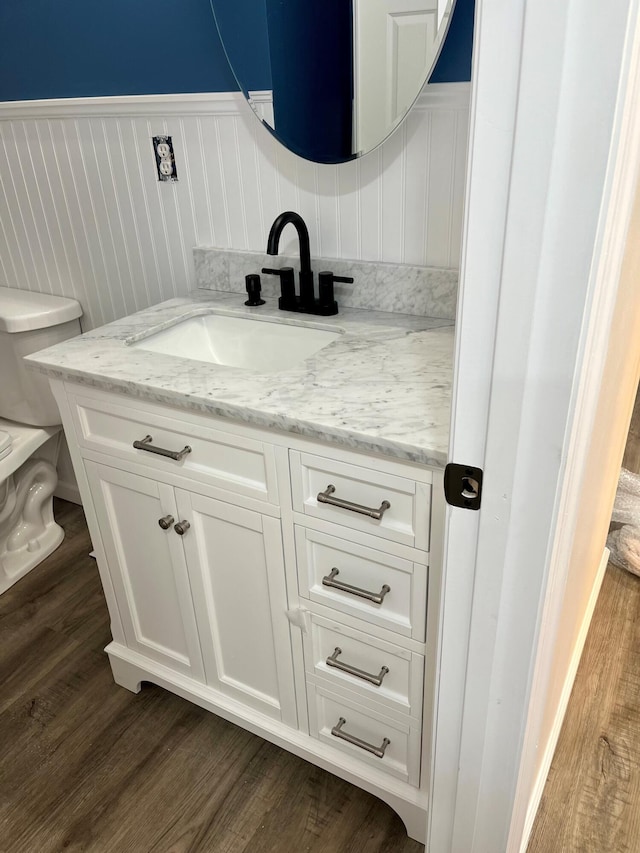 bathroom with hardwood / wood-style flooring, vanity, and toilet