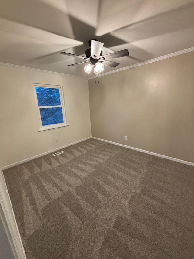 spare room with crown molding, dark carpet, and ceiling fan