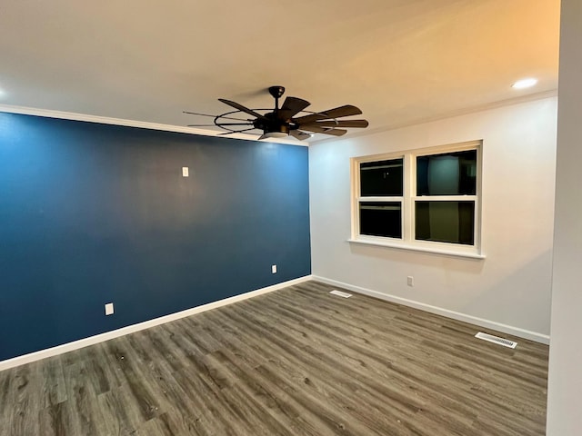 spare room featuring crown molding, dark wood-type flooring, and ceiling fan