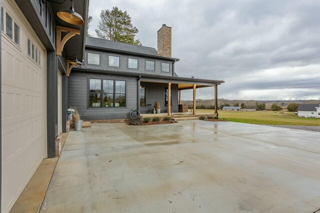 back of house featuring a porch and a garage