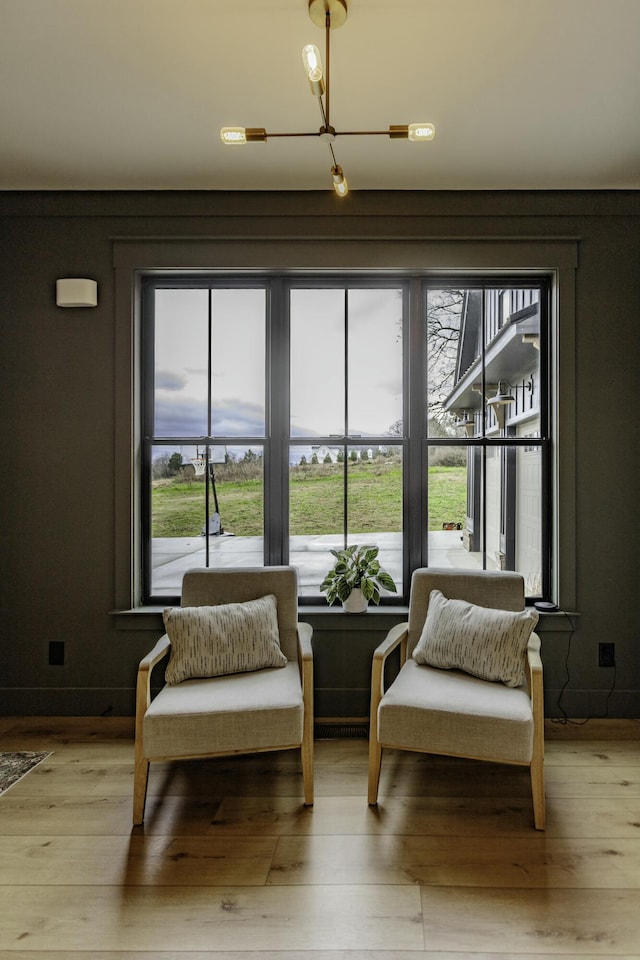 sitting room featuring plenty of natural light, a chandelier, and light hardwood / wood-style floors