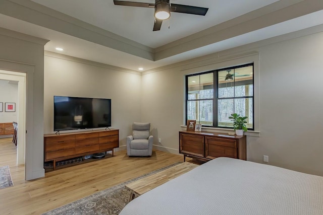 bedroom featuring hardwood / wood-style flooring, ceiling fan, and a raised ceiling