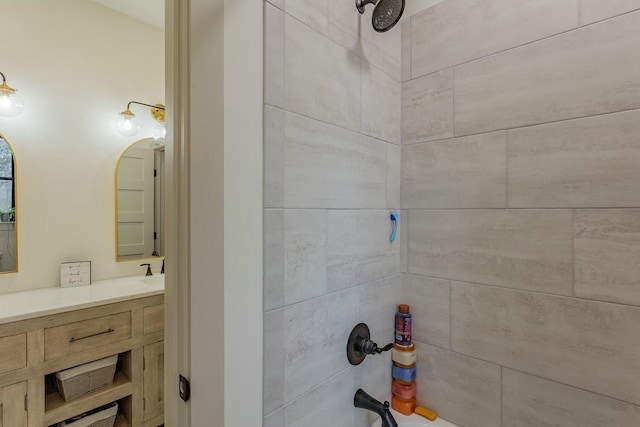 bathroom featuring vanity and tiled shower / bath