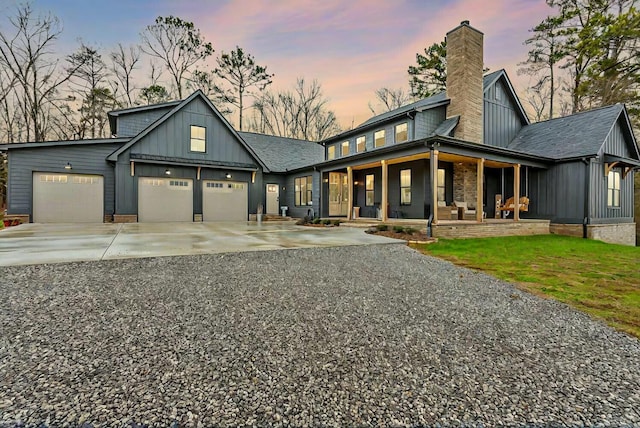 modern farmhouse featuring covered porch and a garage