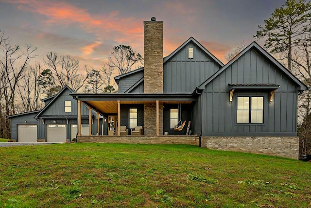 view of front of property featuring a porch, a garage, and a yard