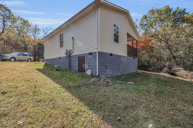 view of side of home with a yard and a balcony