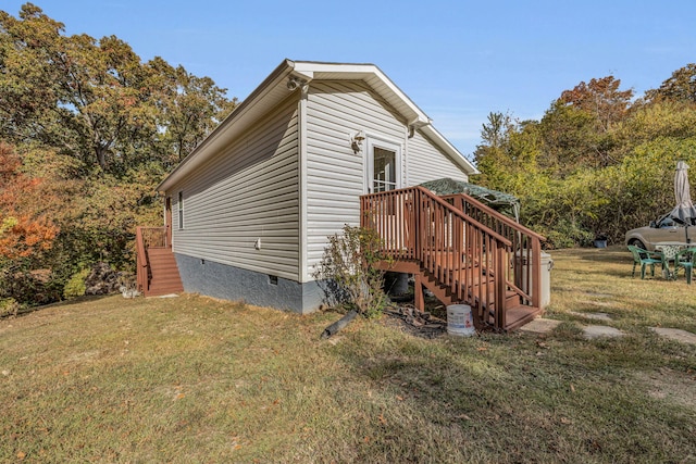 view of side of property with a lawn and a wooden deck