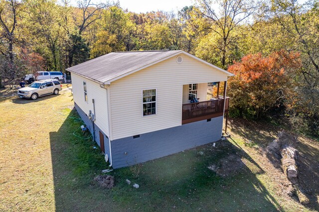 view of side of home with a yard and a porch