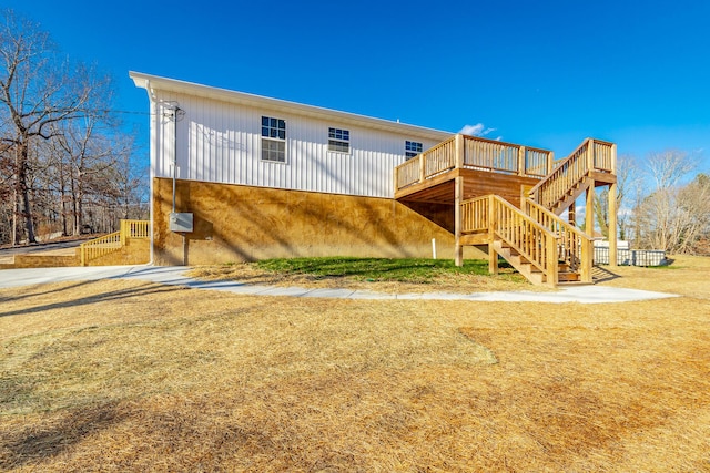 rear view of house featuring a lawn and a wooden deck