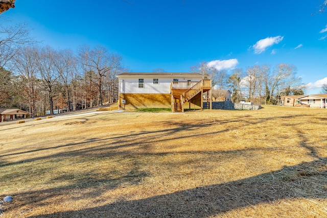 back of property featuring a wooden deck and a lawn