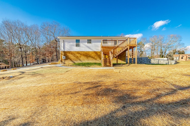 rear view of property featuring a yard and a wooden deck