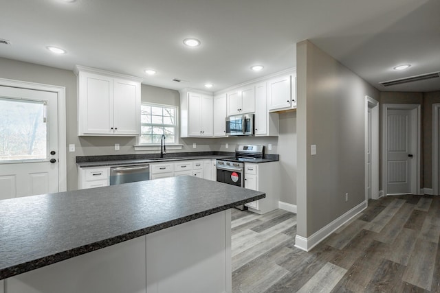 kitchen featuring stainless steel appliances, dark hardwood / wood-style floors, white cabinets, and sink