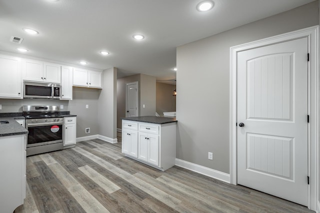 kitchen featuring stainless steel appliances, white cabinets, and light hardwood / wood-style flooring