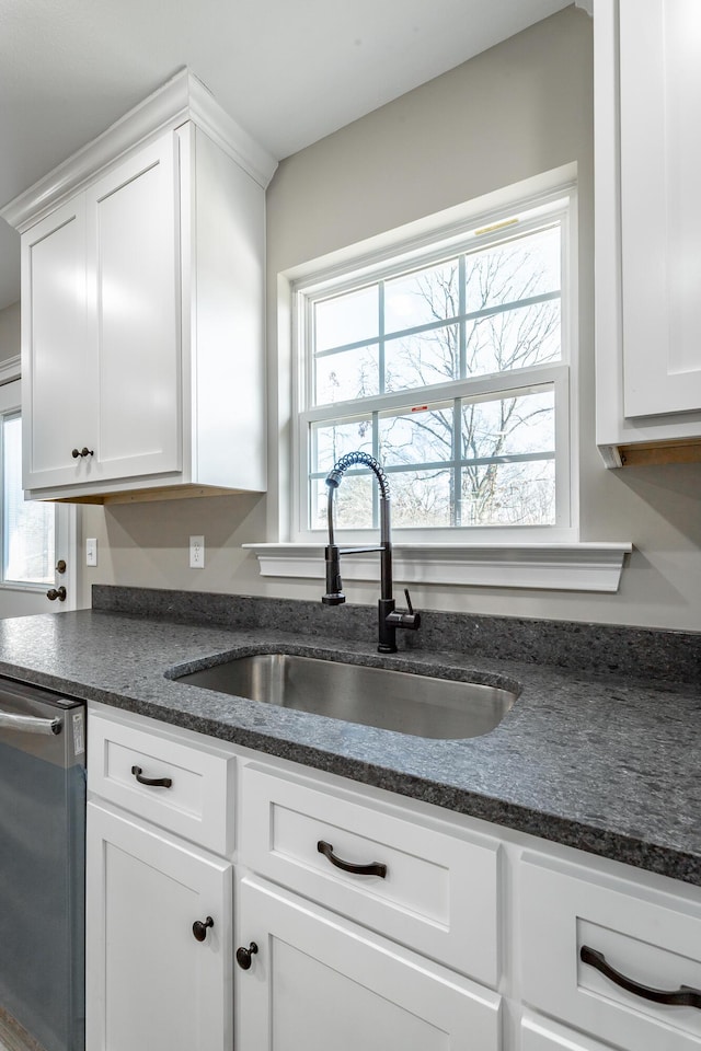 kitchen with white cabinets, stainless steel dishwasher, and sink