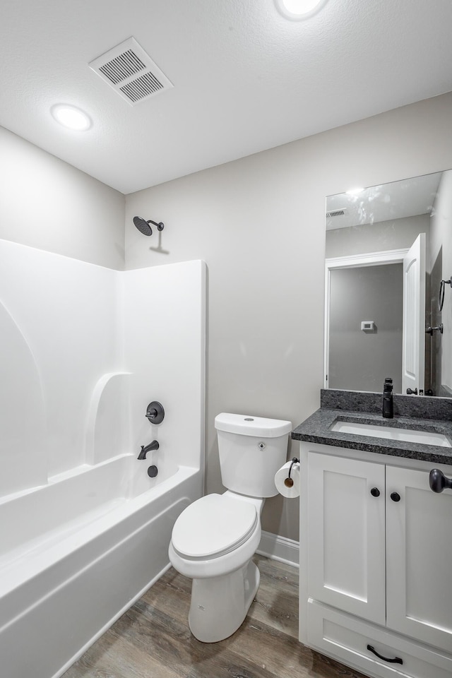 full bathroom with shower / tub combination, toilet, vanity, and hardwood / wood-style flooring