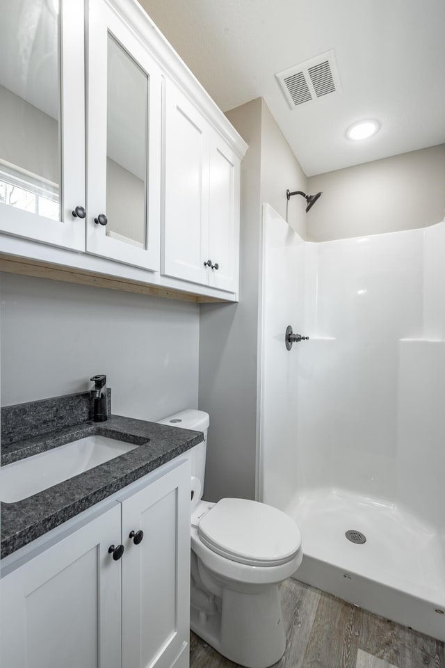 bathroom with toilet, walk in shower, wood-type flooring, and vanity