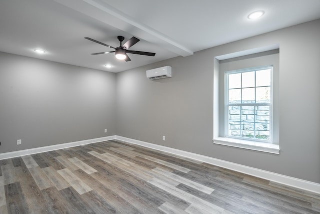 spare room featuring ceiling fan, hardwood / wood-style floors, and an AC wall unit