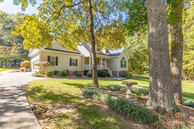 view of front of home featuring a front yard, covered porch, and a garage