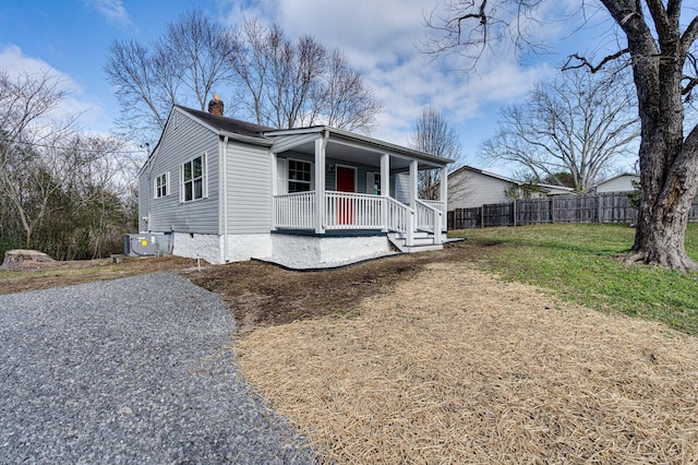 view of side of property with a lawn, covered porch, and central AC