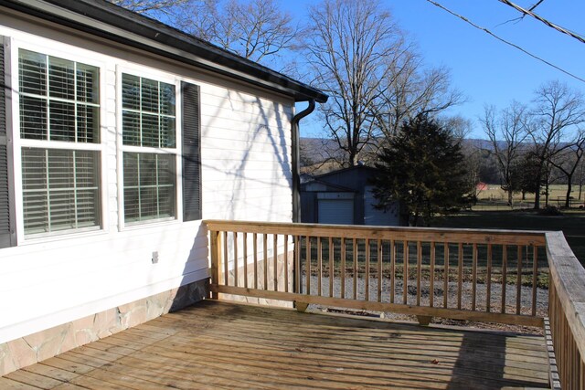 wooden deck with an outdoor structure and a garage