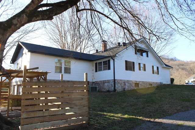 view of property exterior with a lawn and cooling unit