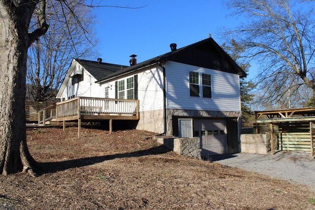 view of home's exterior featuring a garage and a deck