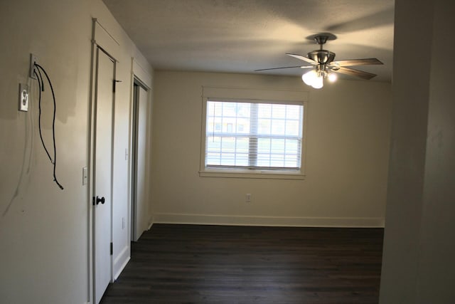 unfurnished bedroom with ceiling fan and dark hardwood / wood-style flooring