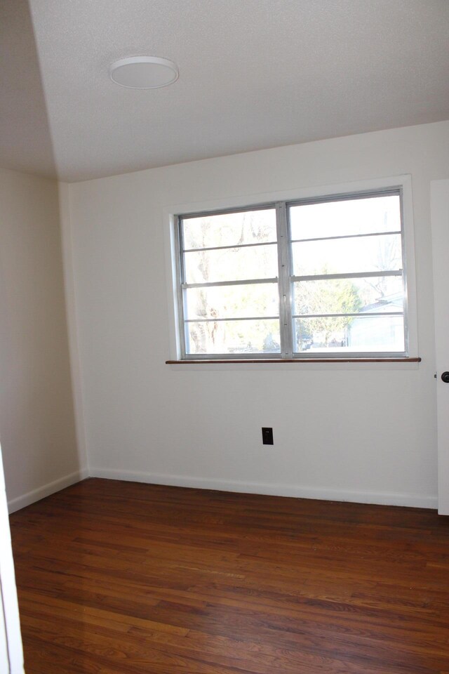 empty room featuring dark hardwood / wood-style floors and plenty of natural light