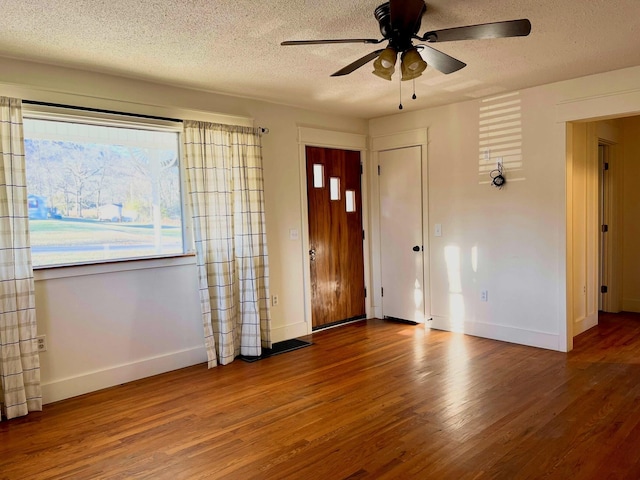 foyer entrance with ceiling fan, hardwood / wood-style floors, and a textured ceiling