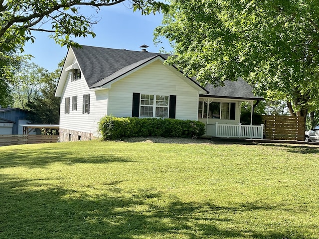 view of front facade with fence, a shingled roof, and a front lawn