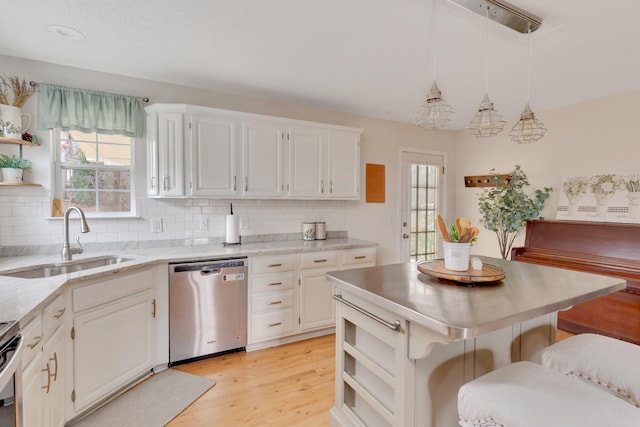 kitchen with dishwasher, white cabinetry, sink, hanging light fixtures, and a breakfast bar