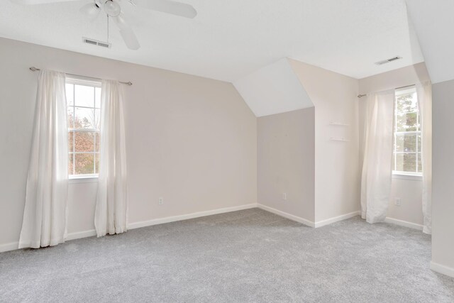 bonus room featuring ceiling fan, a wealth of natural light, light carpet, and lofted ceiling