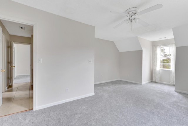 additional living space with light carpet, ceiling fan, and vaulted ceiling